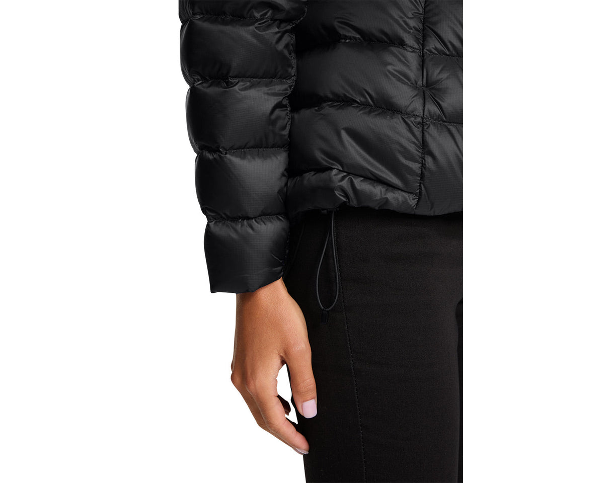 Close-up of a person wearing a black puffer jacket on a white background