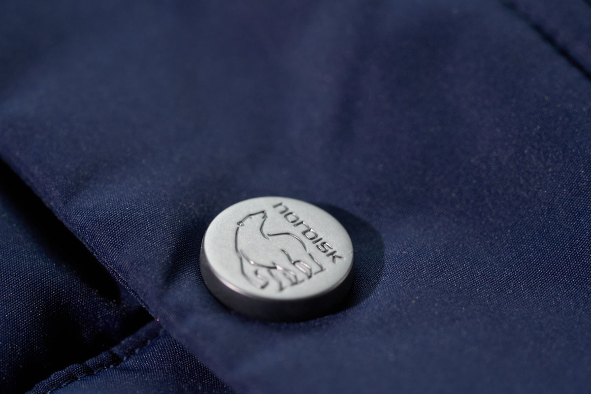 Nordisk logo on a button of a navy blue jacket