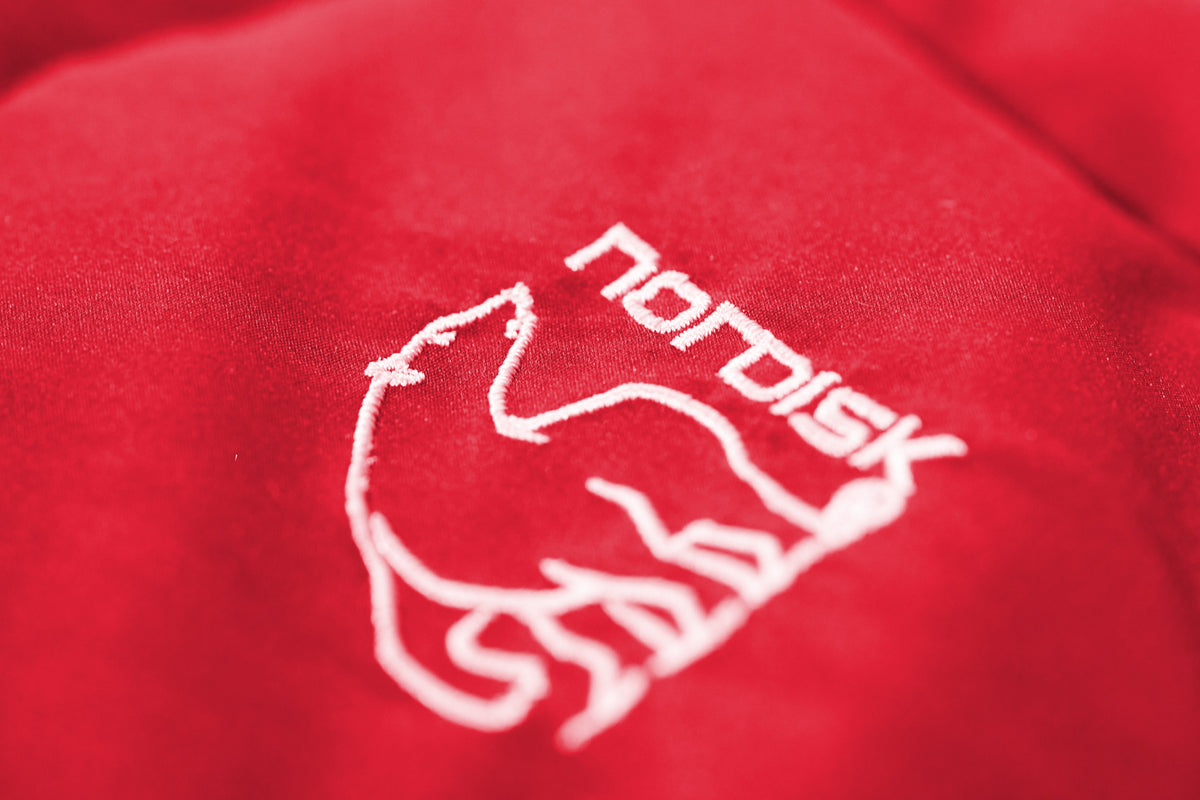 Close-up of a red fabric with a white logo on a red background