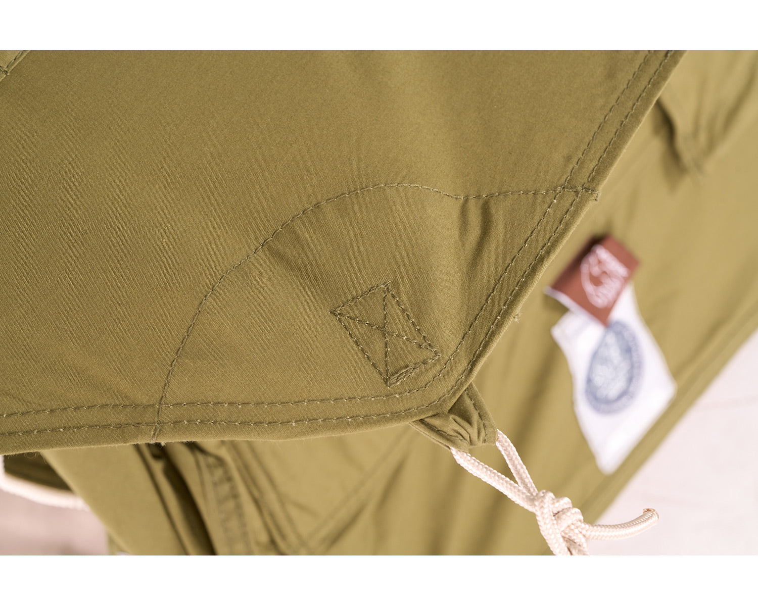 Close-up of a green jacket with a brand label on a white background
