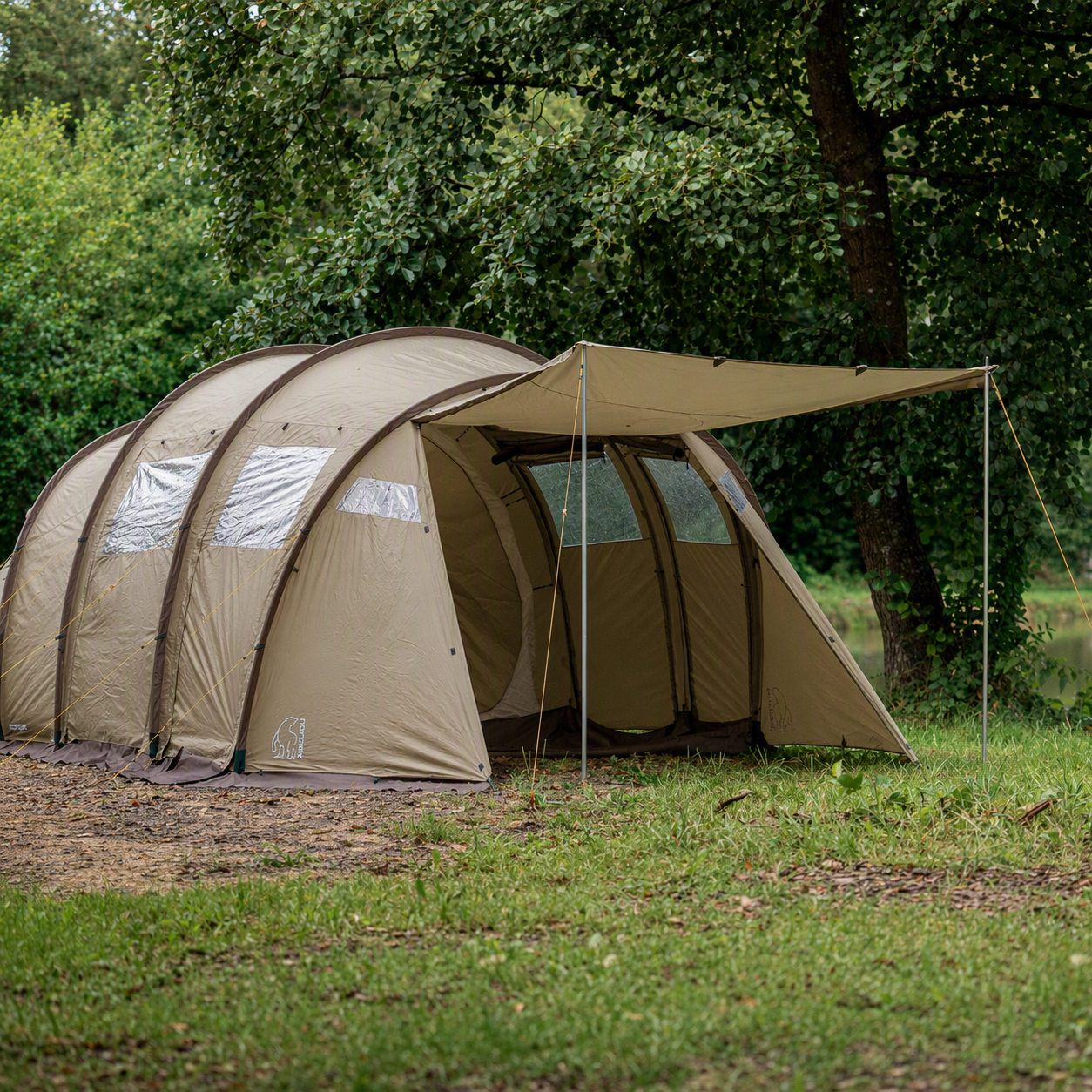 Beige tent with a canopy in a forest setting