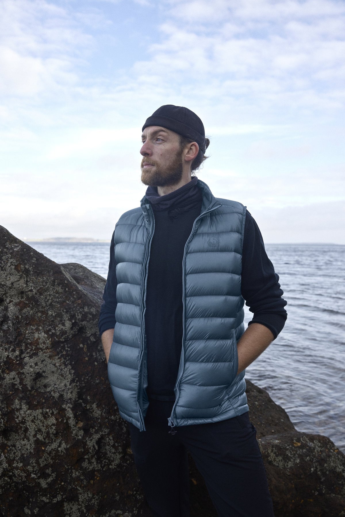 Mann in der Companyon Daunenweste Harald in Blue Mirage am Meer